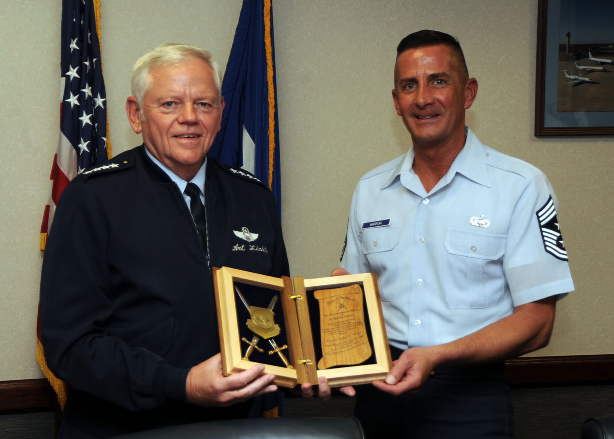 Command Chief Master Sgt. Joe Barron, Air Mobility Command?s top enlisted manager, presents Gen. Arthur Lichte, AMC commander, with a plague this week notifying the general of his nomination for induction into the AMC Order of the Sword.  The Order of the Sword is patterned after an order of chivalry founded during the Middle Ages -- the Swedish Royal Order of the Sword.  Ancient noncommissioned officers would honor their leaders and pledge their loyalty by ceremoniously presenting the leaders with a sword.  The sword -- a symbol of truth, justice and power rightfully used -- served as a token of esteemed leadership.