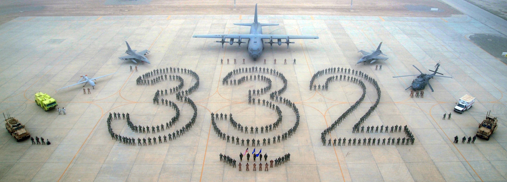 JOINT BASE BALAD, Iraq -- Approximately 500 members of the 332nd Air Expeditionary Wing, including reservists and an F-16 (pictured top left) deployed from Homestead Air Reserve Base, stand in formation as part of an historic photo with: retired Lt. Col. Alexander Jefferson; retired Lt. Col. James Warren; retired Maj. George Boyd; and former Staff Sgt. Philip Broome, all Original Tuskegee Airmen; and Lt. Gen. Gary North, 9th Air Force and U.S. Air Forces Central commander, on April 24. The 332nd AEW traces its military lineage back to the 332nd Fighter Group in World War II, which was comprised of the famous Tuskegee Airmen. (U.S. Navy photo/Navy Chief Sean Mulligan)