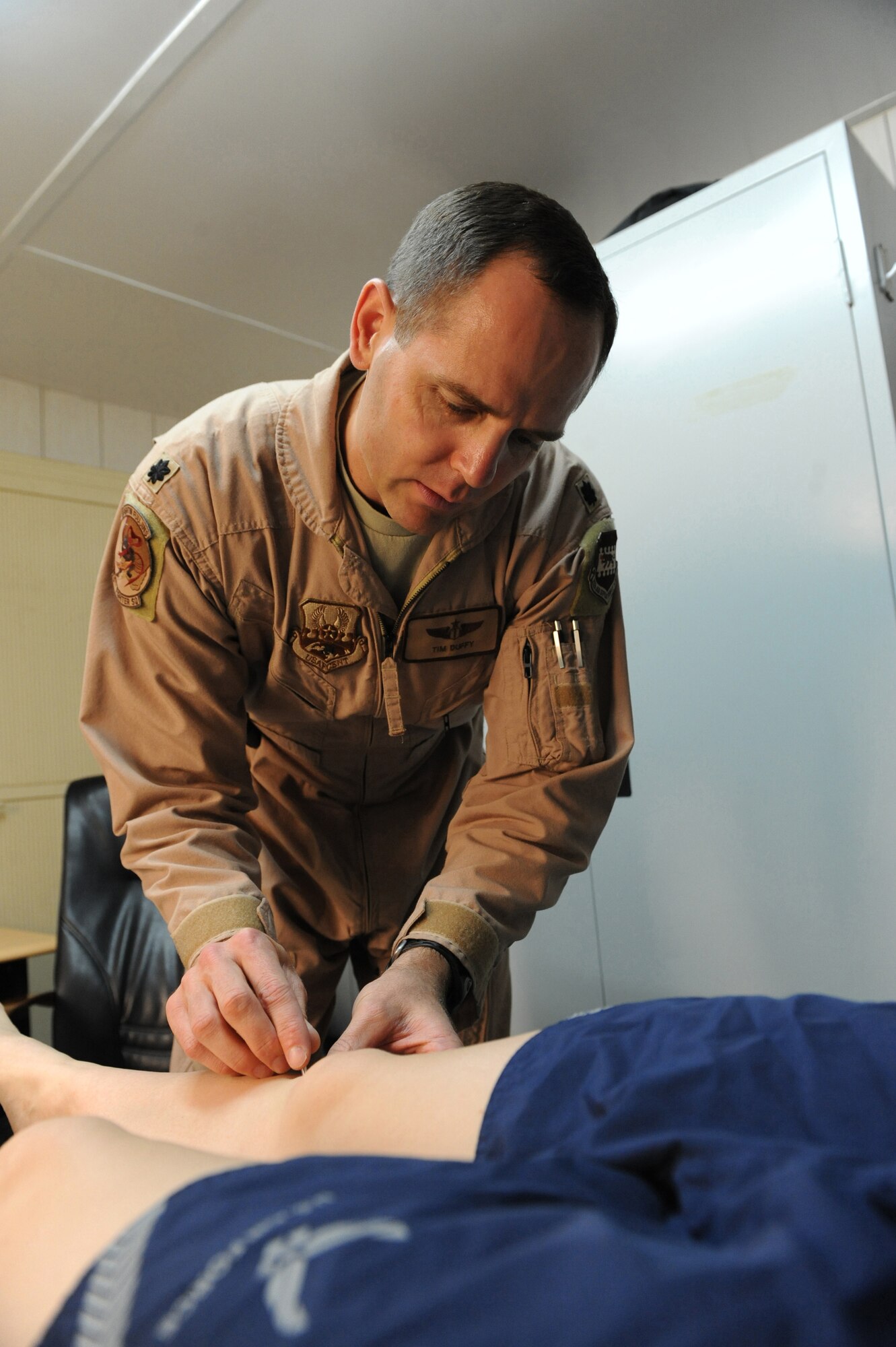 JOINT BASE BALAD, Iraq ? Lt. Col. Tim Duffy, 4th Expeditionary Fighter Squadron flight doctor, administers acupuncture here April 15. By providing both acupuncture and standard anesthetic medication, Air Force doctors have found it possible to achieve a state of pain relief for some patients. Increasingly A native of Boise, Idaho, Colonel Duffy is deployed here from Hill Air Force Base, Utah. (U.S. Air Force photo/Senior Airman Tiffany Trojca)