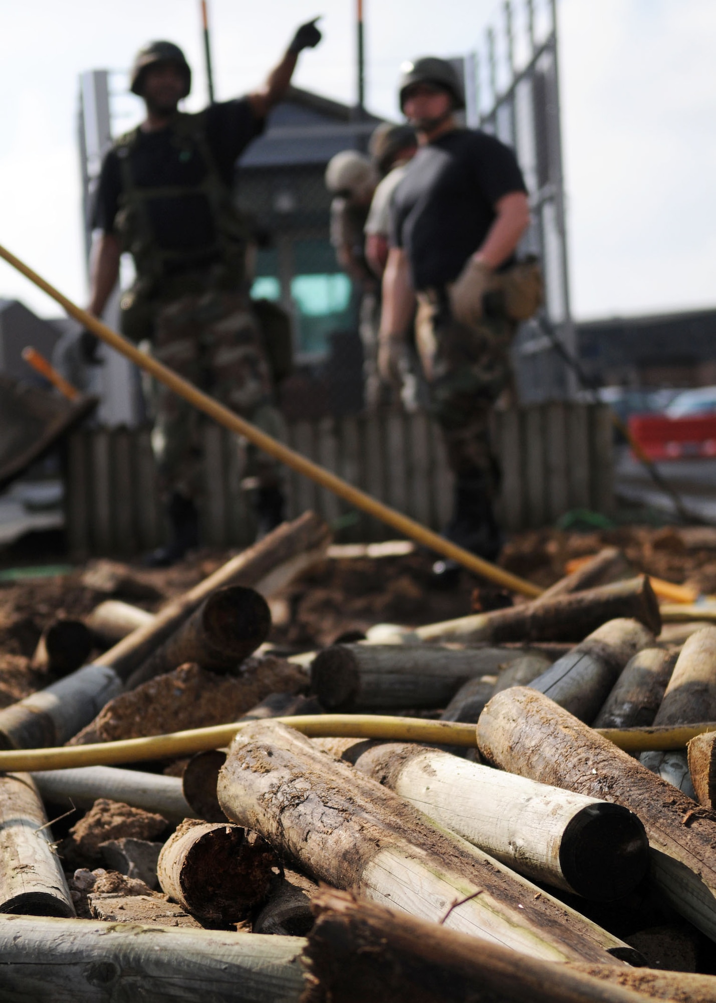 Wooden posts sit in a pile after Staff Sgt. Byron Washington and Senior Airman Joshua Smith, both from the 100th Civil Engineer Squadron, tore down plant boxes at the roundabout near billeting  April 28, 2009, at RAF Mildenhall, England. The project was originally contracted to a civilian company, but for the first time Mildenhall Airmen will perform every aspect of the deconstruction and reconstruction process. According to Master Sgt. Joseph Lamberti, this move was to help CE airmen build team unity and morale while also saving the Air Force thousands of dollars in the process. (U.S. Air Force photo by Staff Sgt. Jerry Fleshman)