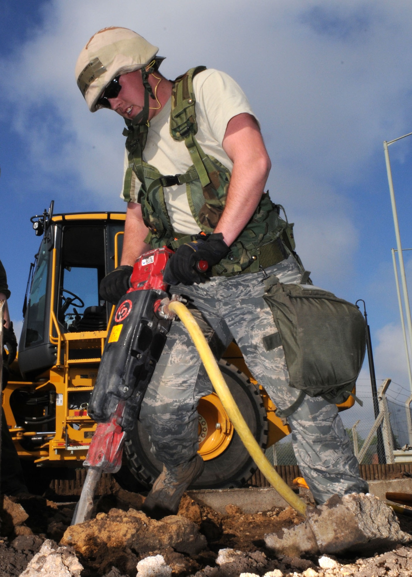 Airman 1st Class Joshua Smith from the 100th Civil Engineer Squadron uses a pneumatic jackhammer to break up concrete and rocks during the deconstruction of planter boxes at the roundabout near billeting April 28, 2009, at RAF Mildenhall, England.  The project was originally contracted to a civilian company, but for the first time Mildenhall Airmen will perform every aspect of the deconstruction and reconstruction process. According to Master Sgt. Joseph Lamberti, this move was to help CE airmen build team unity and morale while also saving the Air Force thousands of dollars in the process. (U.S. Air Force photo by Staff Sgt. Jerry Fleshman)