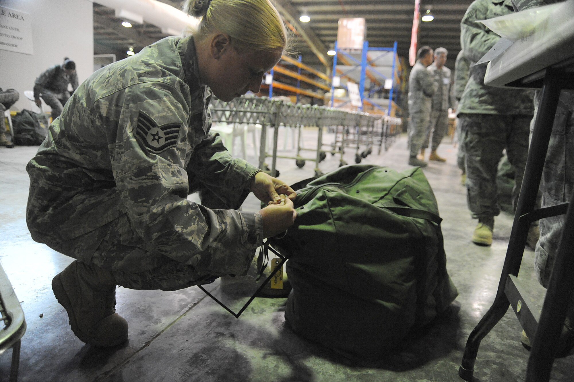 Staff Sgt. Angela Dawson, 380th Expeditionary Logistics Readiness Squadron, zip-ties a plastic sleeve to a C-bag during a readiness exercise, April 21 at undisclosed location in Southwest Asia. The plastic sleeve will hold a form 1297 hand receipt with the inventory of the C-bag listed. The 380th ELRS ran the exercise to test the timeliness and capability for redeployment of Airmen. Sergeant Dawson is deployed from Eglin AFB, Fla. and hails from Tallahassee, Fla. (U.S. Air Force photo by Senior Airman Brian J. Ellis) (Released)