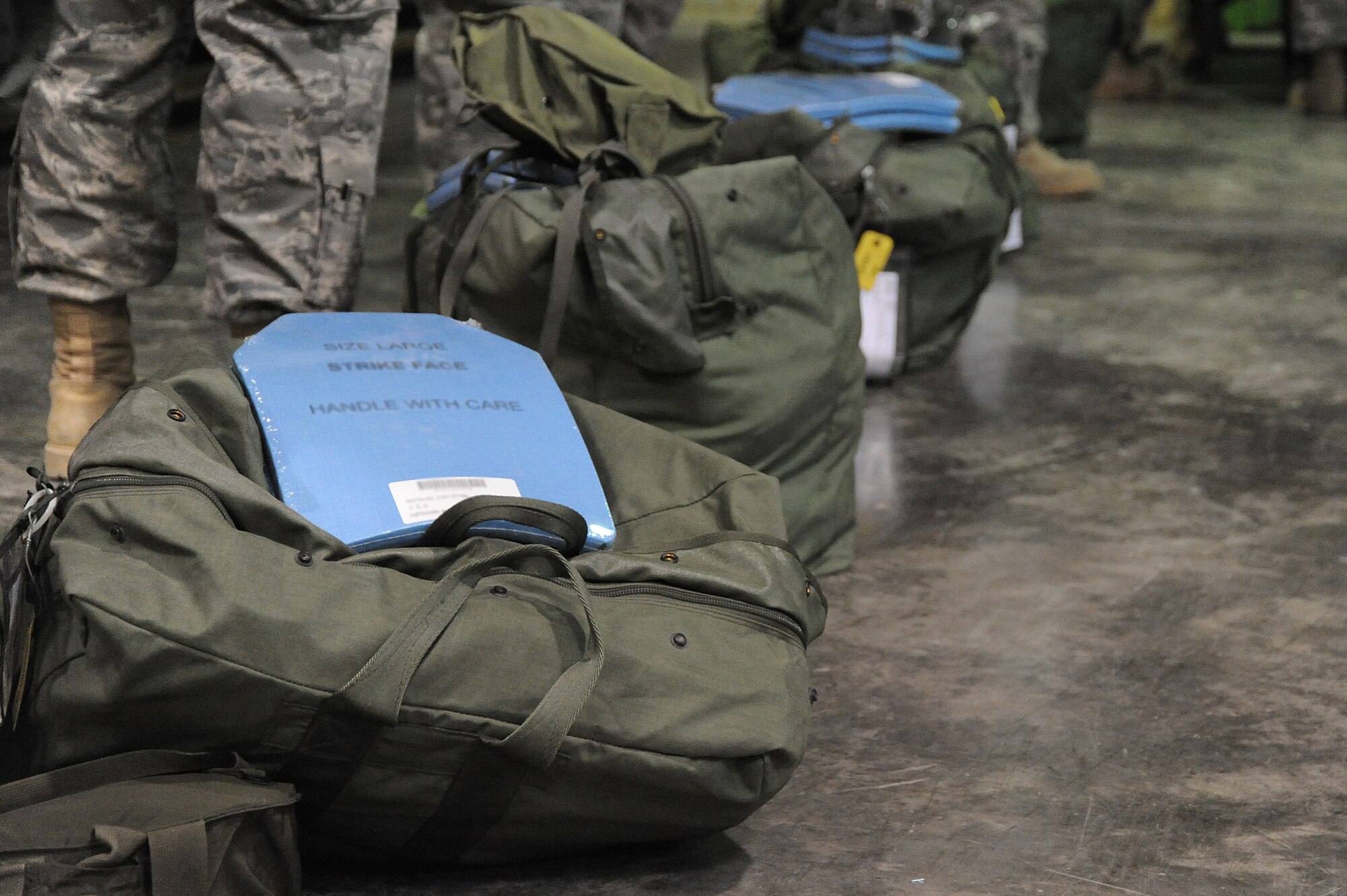 Airmen of the 380th Air Expeditionary Wing stand by their mobility bags as they process through a deployment line during a readiness exercise, April 21 at undisclosed location in Southwest Asia. The 380th ELRS ran the exercise to test the timeliness and capability for redeployment of Airmen. (U.S. Air Force photo by Senior Airman Brian J. Ellis) (Released)