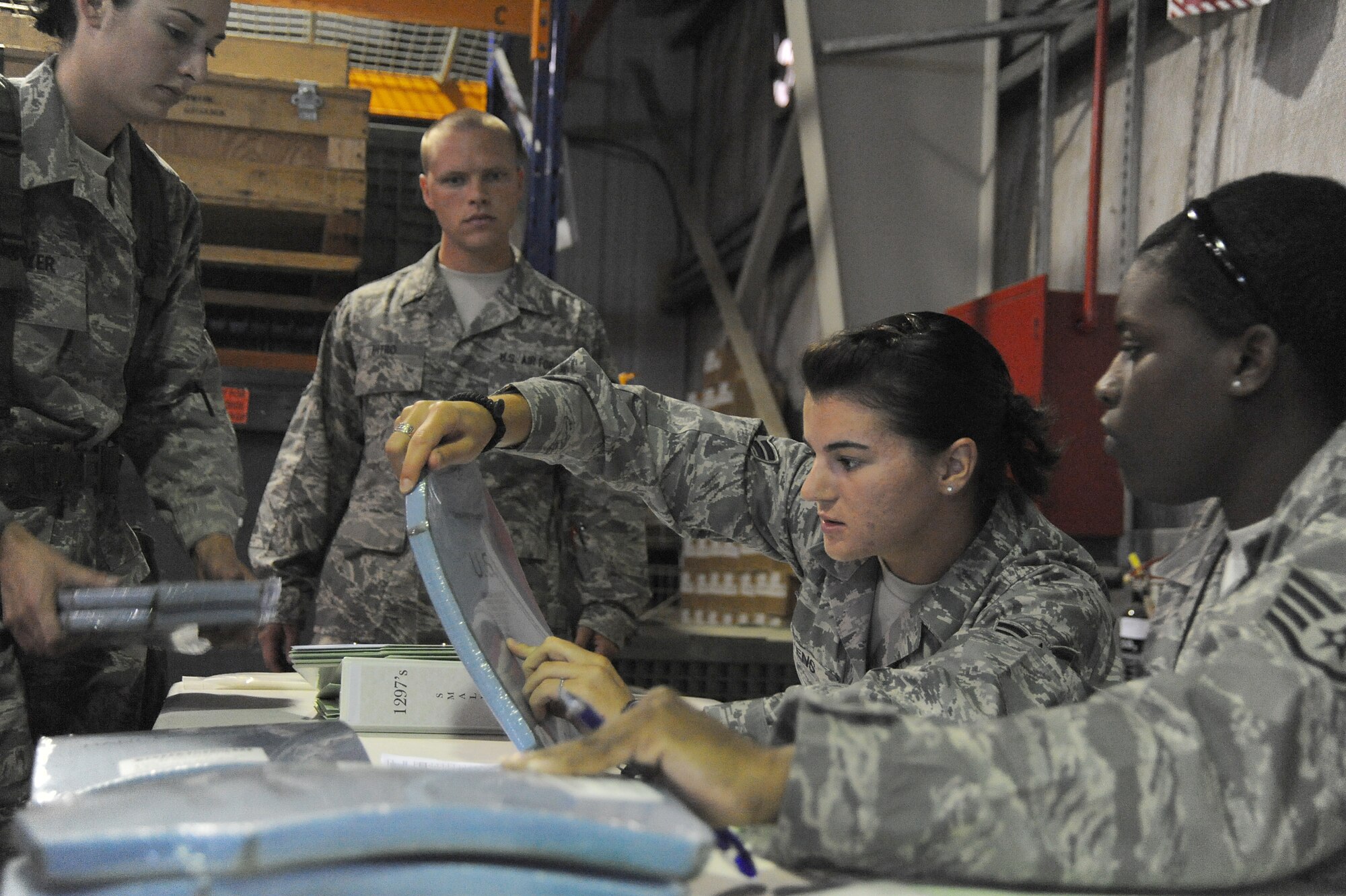 Staff Sgt. Deandrea Dorsey and Airman 1st Class Venus Owens, 380th Expeditionary Logistics Readiness Squadron, verify serial numbers on body armor plates against numbers on form 1297's for accountability during a readiness exercise, April 21 at undisclosed location in Southwest Asia. The 380th ELRS ran the exercise to test the timeliness and capability for redeployment of Airmen. Sergeant Dorsey is deployed from Hurlburt Field, Fla. and hails from West Memphis, Ark. Airman Owens is deployed from Eglin AFB, Fla. and is from Azle, Texas. (U.S. Air Force photo by Senior Airman Brian J. Ellis) (Released)