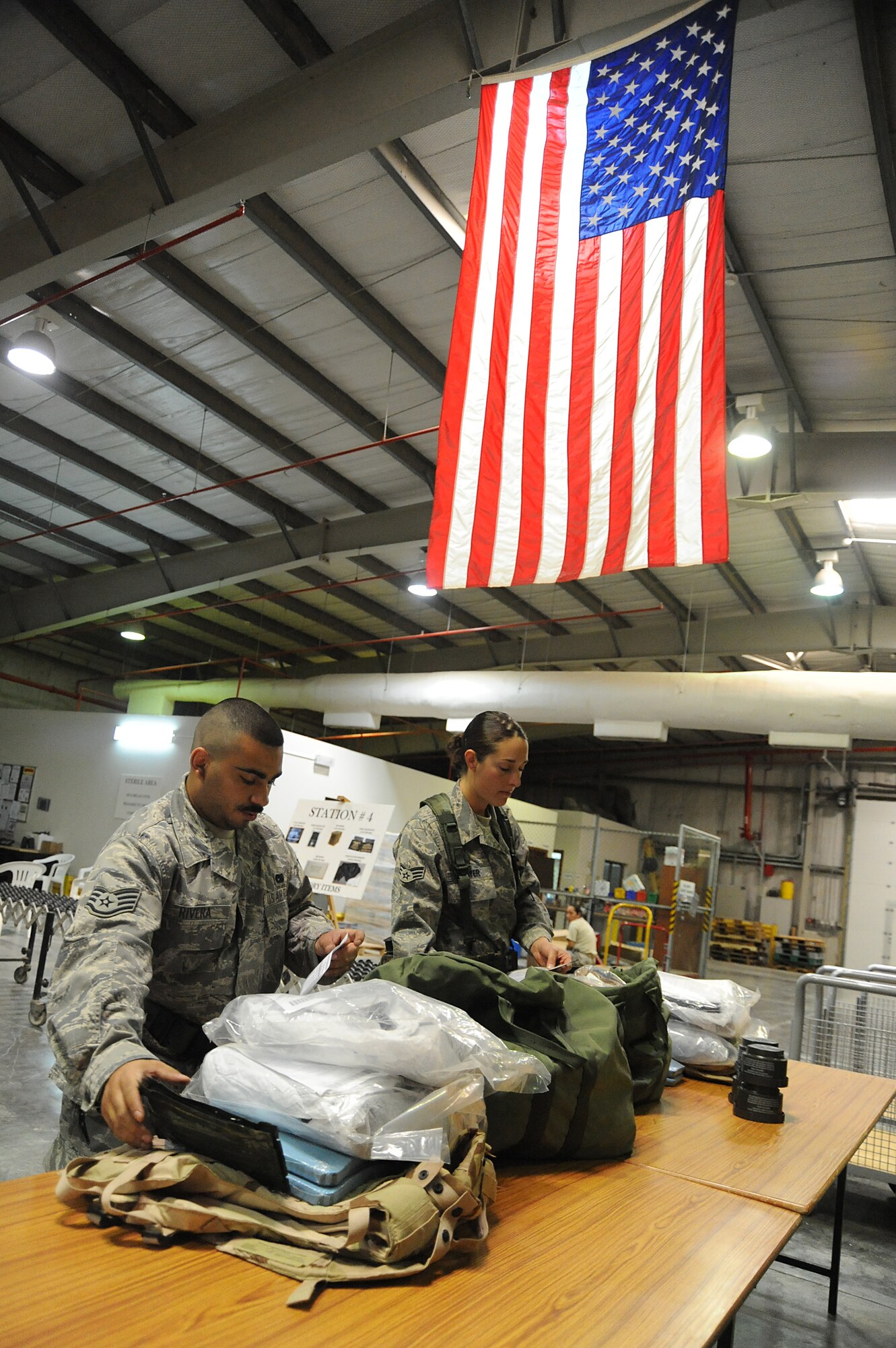 Staff Sgt. Israel Rivera and Senior Airman Rochelle Boyer, 380th Expeditionary Logistics Readiness Squadron, inventory their C-bags in a deployment processing line during a readiness exercise, April 21 at undisclosed location in Southwest Asia. The 380th ELRS ran the exercise to test the timeliness and capability for redeployment of Airmen. Sergeant Rivera is deployed from RAF Lakenheath, England and hails from Bronx, N.Y. Airman Boyer is deployed from Spagdahlem Air Base, Germany and hails from Reno, Nev. (U.S. Air Force photo by Senior Airman Brian J. Ellis) (Released)