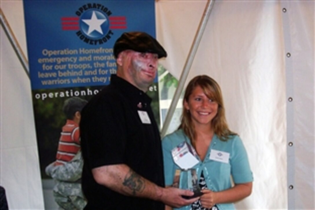 Brittany Wallace, 17, stands beside her father, Army Staff Sgt. Robert Henline, as they hold the 2009 Military Child Award she received from Texas-based Operation Homefront in Washington, D.C., April 29, 2009. The award honors her for the support she gave her family and father, the lone survivor of a roadside bomb in Iraq that burned 38 percent of his body.
