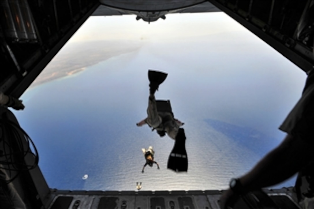 A U.S. Air Force pararescueman jumps out of a C-130P aircraft, during a training exercise over Djibouti, April 23, 2009. The exercise consisted of transporting pararescuemen to their water jump, aerial refueling of a CH-53E helicopter, an assault landing on an unimproved runway, and transloading a simulated survivor from the CH-53E. The paraescuemen are assigned to the 82nd Rescue Squadron.