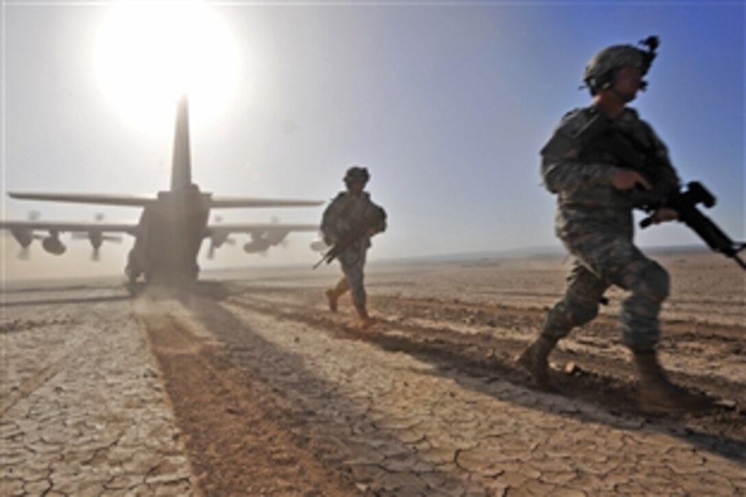 U.S. Army soldiers run to set-up a perimeter around a U.S. Air Force HC-130, during a pararescueman training exercise in Djibouti, April 23, 2009. The soldiers are assigned to the 2nd Battalion,18th Field Artillery Regiment.
