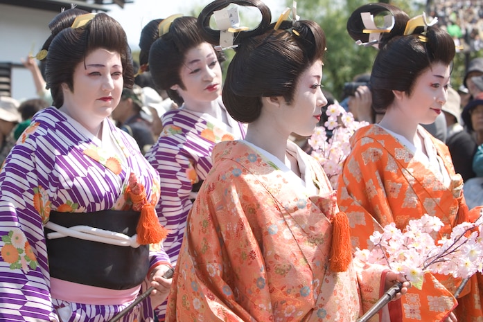 Katie Zirkle (left) and Tyra Morgan (center) walk as lady maids during the 32nd annual Kintai-kyo Festival at Kikko Park April 29. Zirkle and Morgan endured more than two-hours of make-up application, dressing up and walking practice to prepare for their role in the procession.