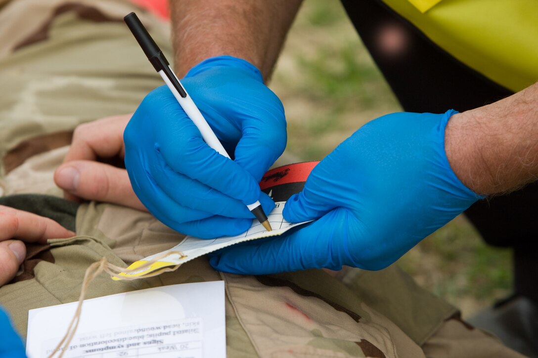 Ellis Pauley, a paramedic firemen, Camp Lejeune Fire and Emergency Services, fills out a Mass Casualty Tag for Pfc. Jermiah Gallagher, a student with the Marine Corps Engineer School, is treated for simulated chemical injuries during the full-scale antiterrorism exercise ‘Urgent Response 2009’ held on Camp Lejeune and Marine Corps Air Station New River, April 30. The tag allows quick identifying of a victim, as well as, lists illness he may have.