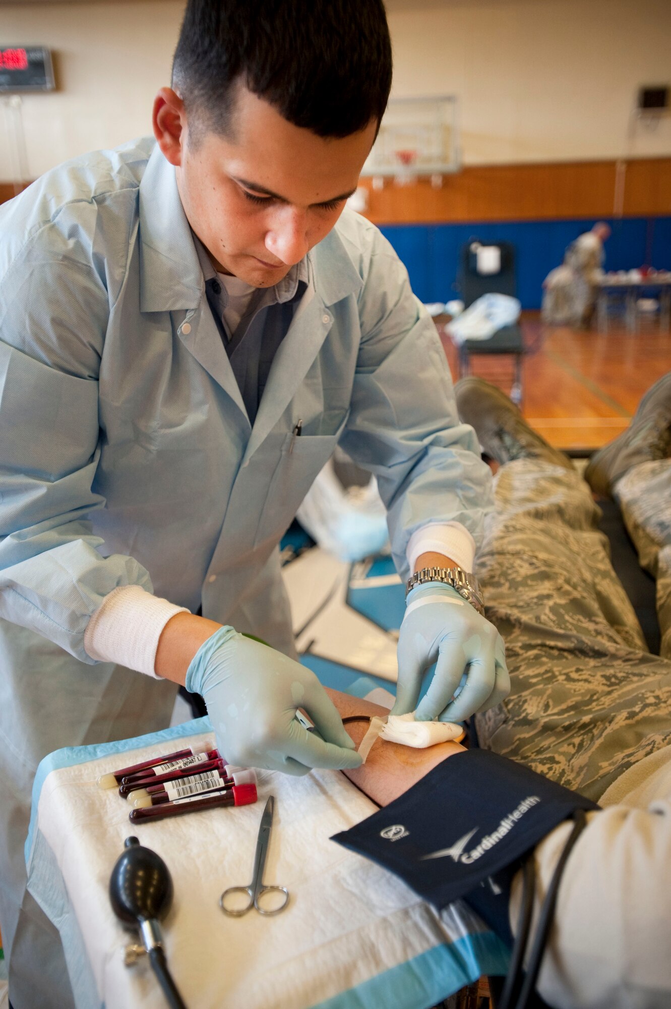 MISAWA AIR BASE, Japan -- Petty Officer 3rd Class David Nunez, Armed Services Blood Bank technician, applies a dressing to the arm of 1st Lt. Eric Miller, 35th Civil Engineer Squadron programs development officer, at the Potter Fitness Center April 28, 2009. The blood bank travels across the Pacific region collecting blood from American service members. (U.S. Air Force photo by Staff Sgt. Samuel Morse)
