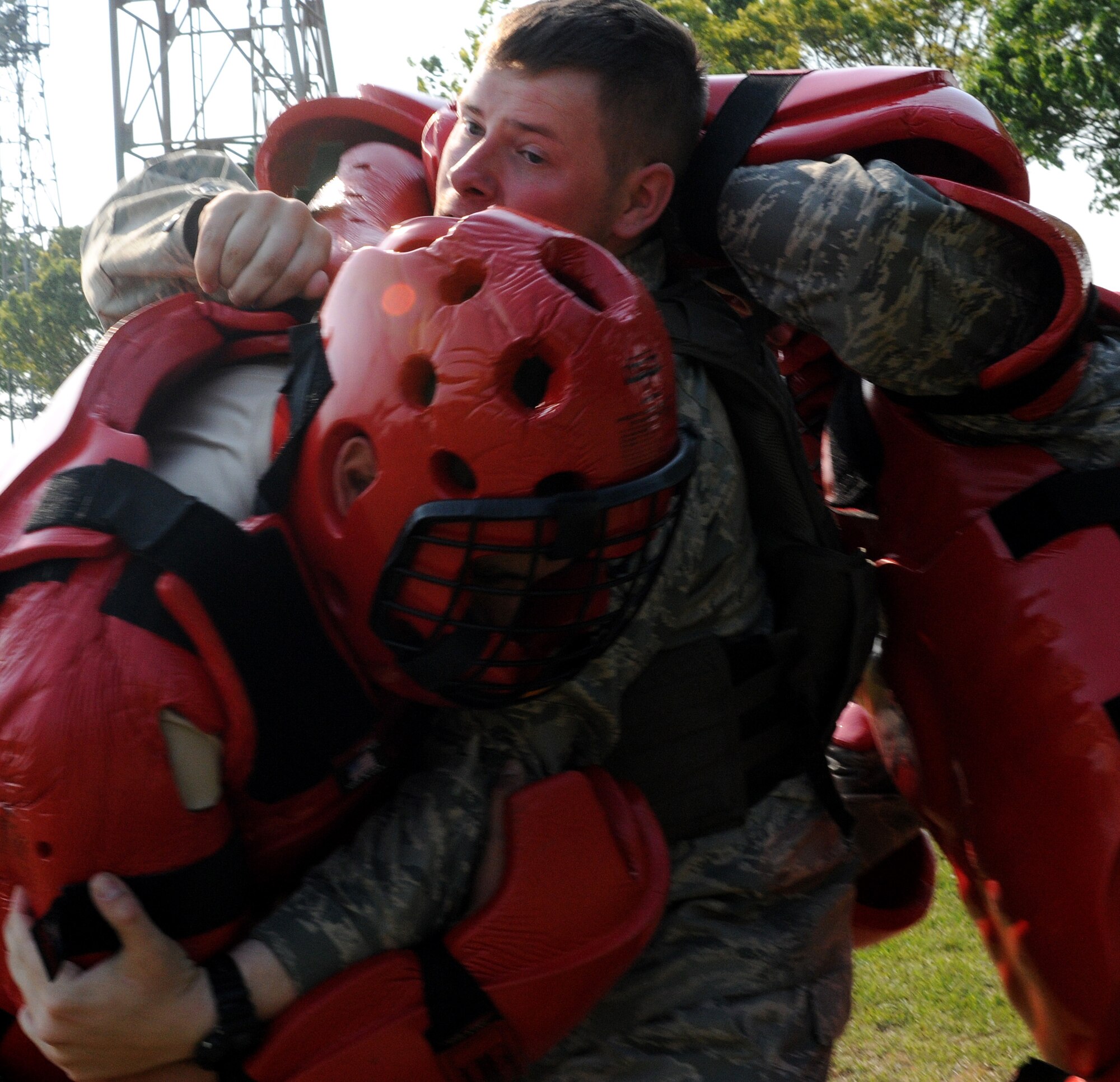 YOKOTA AIR BASE, Japan -- Airman 1st Class Edward Roberts, 374th Security Forces Squadron, takes on the "Red Men" April 30 during combative training. The "Red Man" suit is designed to deliver body protection and mobility needed during the training, based on pressure point control and physical apprehension restraint techniques. Combative training is an annual requirement for security forces members here. (U.S. Air Force photo/Airman 1st Class Michael Dillon)