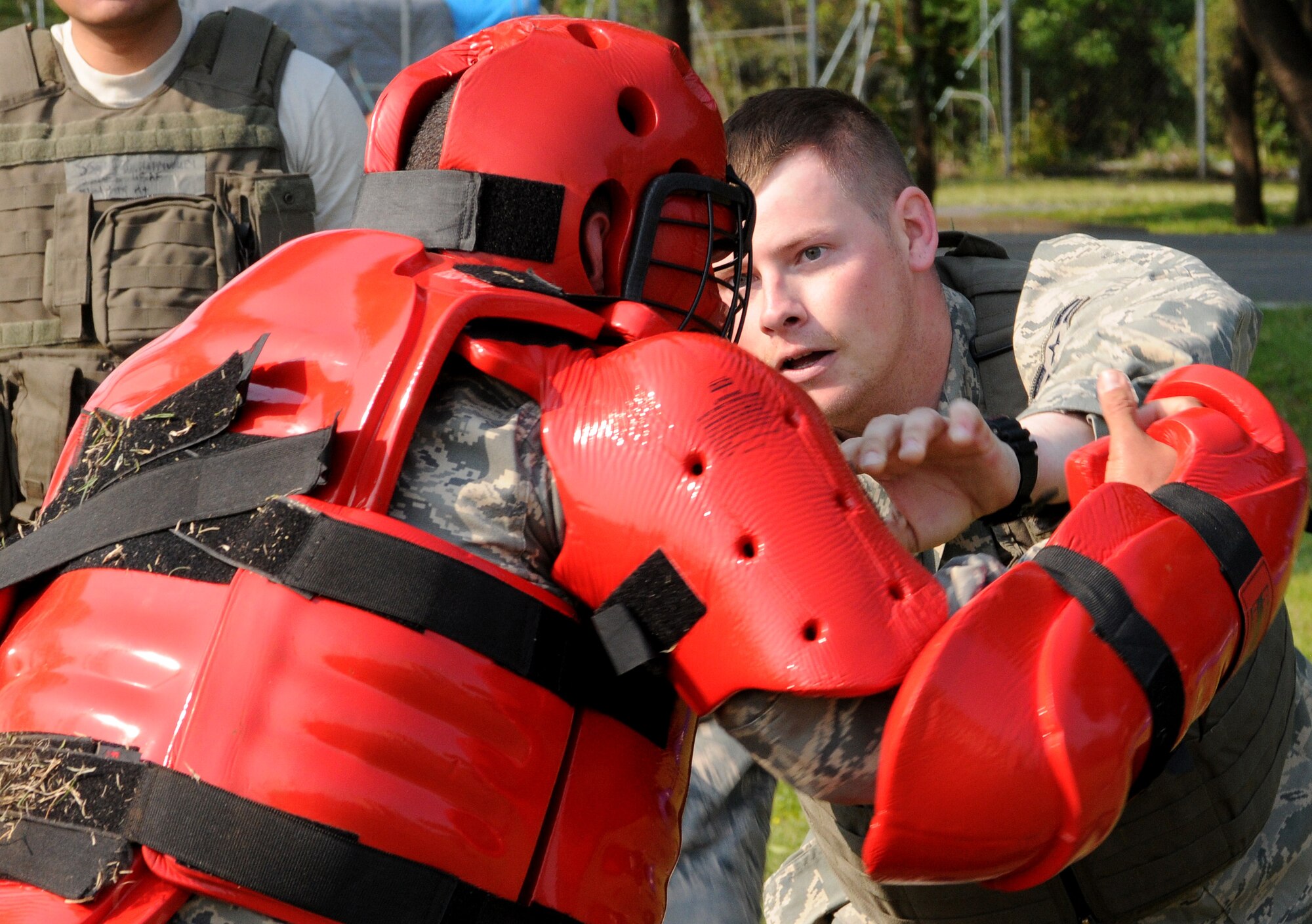 YOKOTA AIR BASE, Japan -- Airman 1st Class Edward Roberts, 374th Security Forces Squadron, takes on the "Red Man" April 30 during combative training. The "Red Man" suit is designed to deliver body protection and mobility needed during the training, based on pressure point control and physical apprehension restraint techniques. Combative training is an annual requirement for security forces members here. (U.S. Air Force photo/Airman 1st Class Michael Dillon)