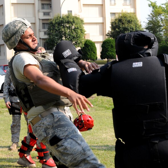 YOKOTA AIR BASE, Japan -- Airman 1st Class Pierre Harden, 374th Security Forces Squadron, receives a blow April 30 during combative training. The training, based on pressure point control and physical apprehension restraint techniques, is an annual requirement for security forces members here. (U.S. Air Force photo/Airman 1st Class Michael Dillon)