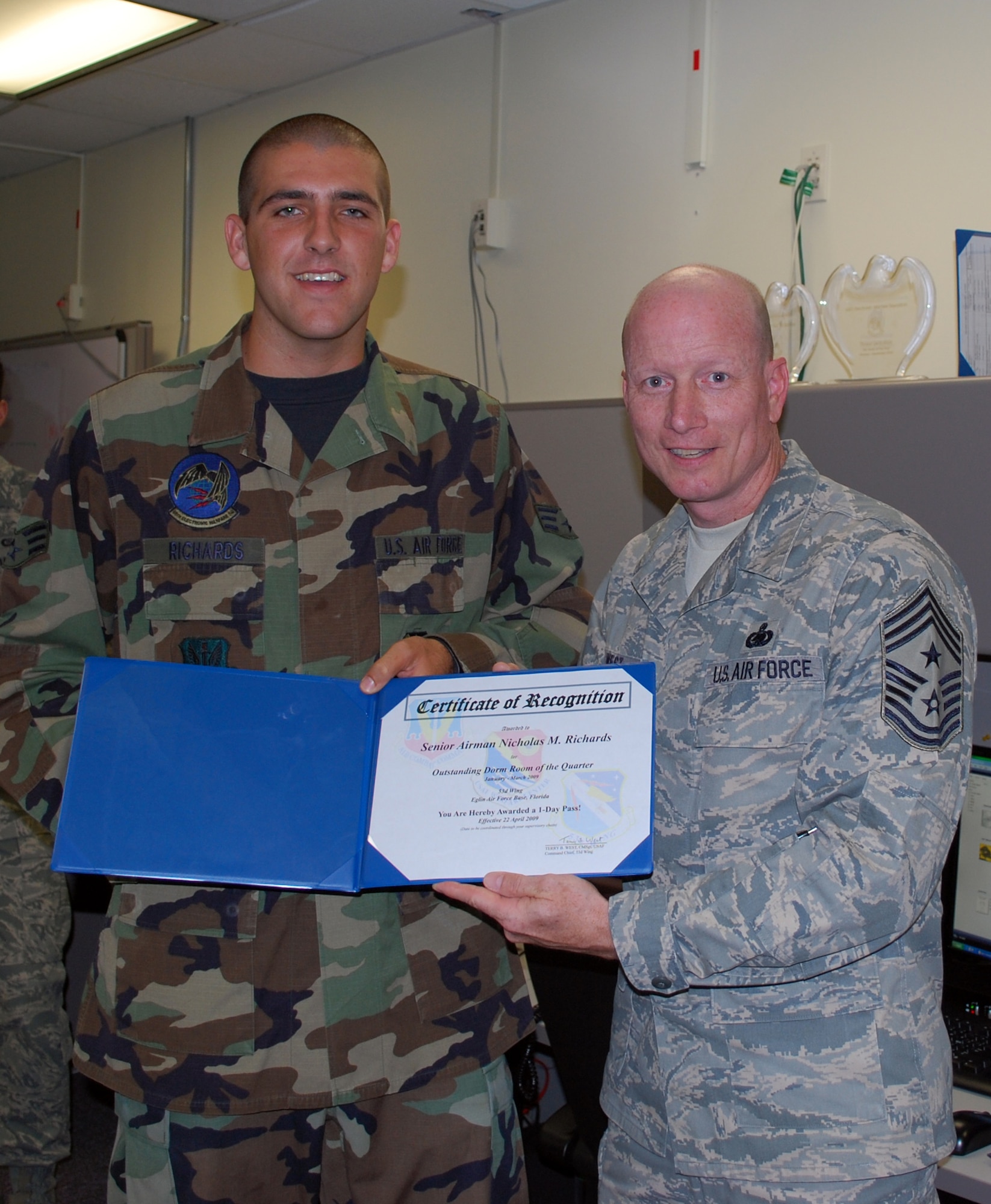EGLIN AIR FORCE BASE, Fla. -- Senior Airman Micholas Richards, 53rd Wing, receives a certificate from Chief Master Sgt. Terry West, 53rd WG command chief, April 22, for going above and beyond hygienic standard of living and making his living quarters truly his. Dorm of the Quarter is a competition designed to recognize Airmen for their efforts to uphold these dorm room standards. (U.S. Air Force photo/ Airman Anthony Jennings)