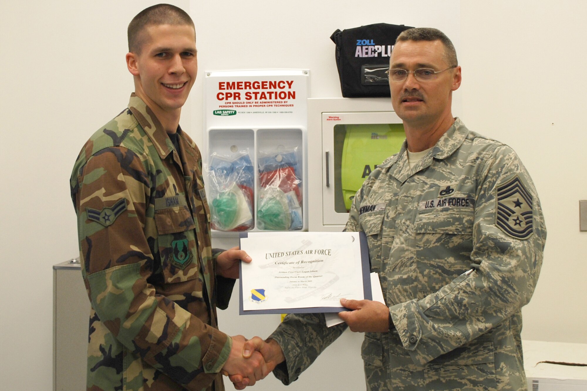 EGLIN AIR FORCE BASE, Fla. -- Airman 1st Class Logan Isham, 46th Air Maintenance Squadron, receives a certificate from Chief Master Sgt. Robert Newman, 46th Test Wing command chief, April 22, for going above and beyond hygienic standard of living and making his living quarters truly his. Dorm of the Quarter is a competition designed to recognize Airmen for their efforts to uphold these dorm room standards. (U.S. Air Force photo/ Airman Anthony Jennings)