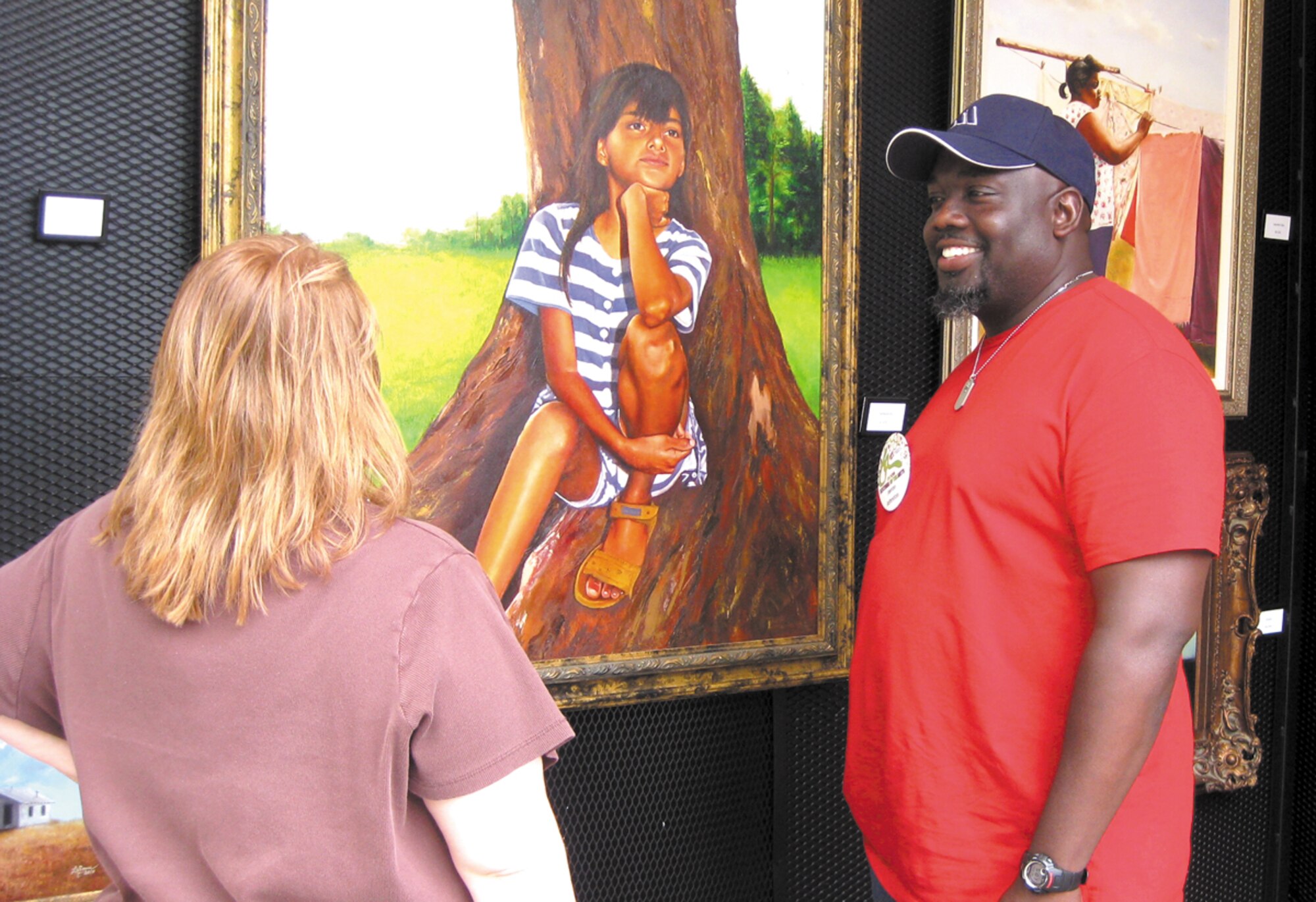 Jerron Johnston, an artist and aircraft electrician with the 564th Aircraft Maintenance Squadron here chats with Donna Martin at the Festival of Arts in Oklahoma City April 23. Mr. Johnston has applied to the festival several times, but this is the first year he has been showcased. The weeklong festival draws artists and patrons from several states. (Air Force photo/April McDonald) 