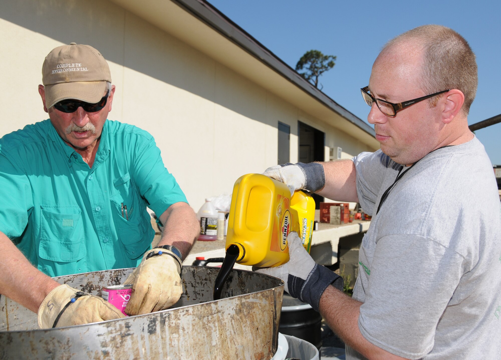 Sonny Hughes, left, and William Rider from Complete Environmental and Remediation Co., Purvis, Miss., collects and packages hazardous household waste for proper recycling or disposal at the recycling center.  (U.S. Air Force photo by Kemberly Groue)