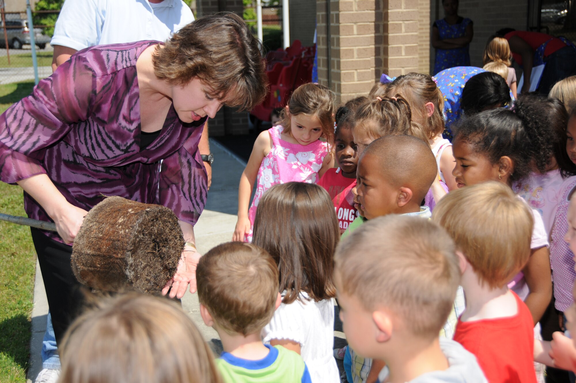 Beth Osgood from CSC at Maxwell Air Force Base, Ala., shows area schoolchildren the root ball of a tree as she explains the importance of trees to the environment during the Great Green Expo, one of Keesler’s Earth-Arbor Day events, April 22.  The day included displays, giveaways, tree plantings, hazardous household waste disposal and tours of the base’s recycling center and Leadership in Energy and Environmental Design homes. (U.S. Air Force photo by Kemberly Groue)