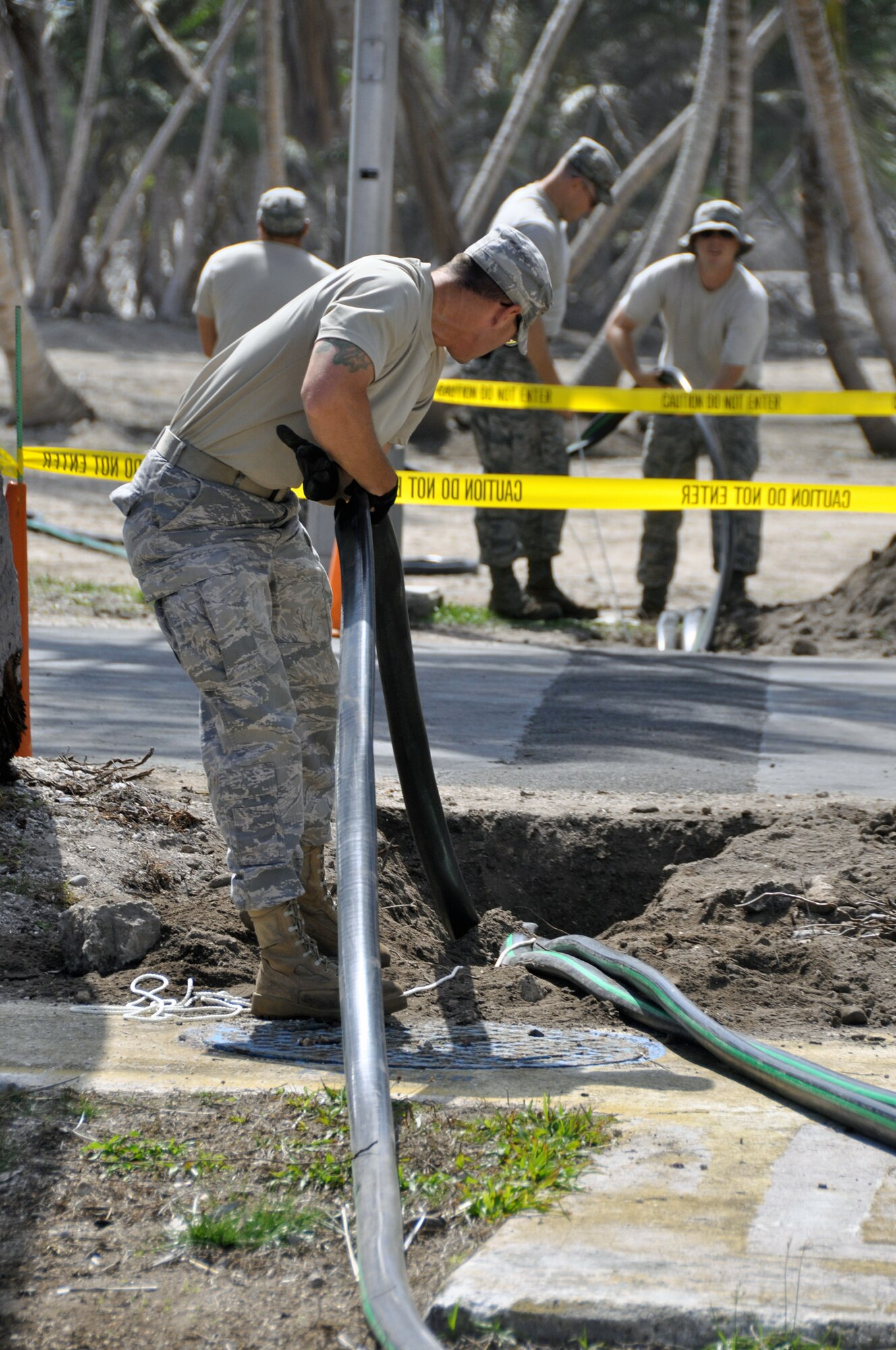 Civil engineer Airmen work to connect tubes to water tanks April 18 to replenish the water supply here that was ruined by unusually high tides in the early part of February at Roi-Namur in the Marshall Islands. The Airmen have treated more than 1,840,000 gallons of water since their arrival. (U.S. Air Force photo/Tech. Sgt. Cohen A. Young) 
