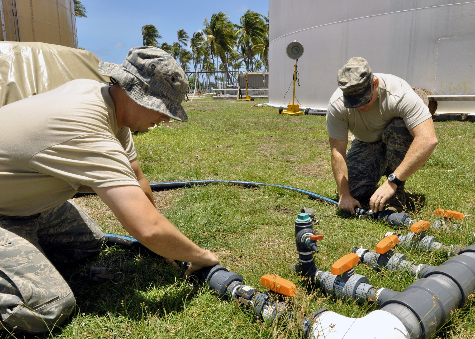 Civil engineer Airmen work to connect tubes to water tanks April 18 to replenish the water supply here that was ruined by unusually high tides in the early part of February at Roi-Namur in the Marshall Islands. The Airmen have treated more than 1,840,000 gallons of water since their arrival. (U.S. Air Force photo/Tech. Sgt. Cohen A. Young) 
