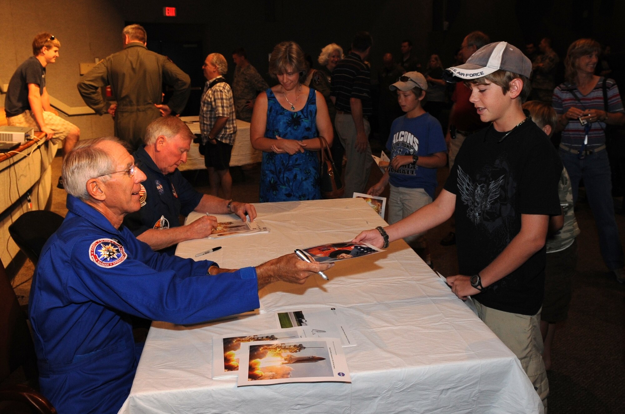 Former astronauts Bob Springer and Jon McBride sign autographs for eager children following the Astronaut Panel held by Detachment 3 April 24 at the Patrick Base Theater. (U.S. Air Force photo/John Connell)