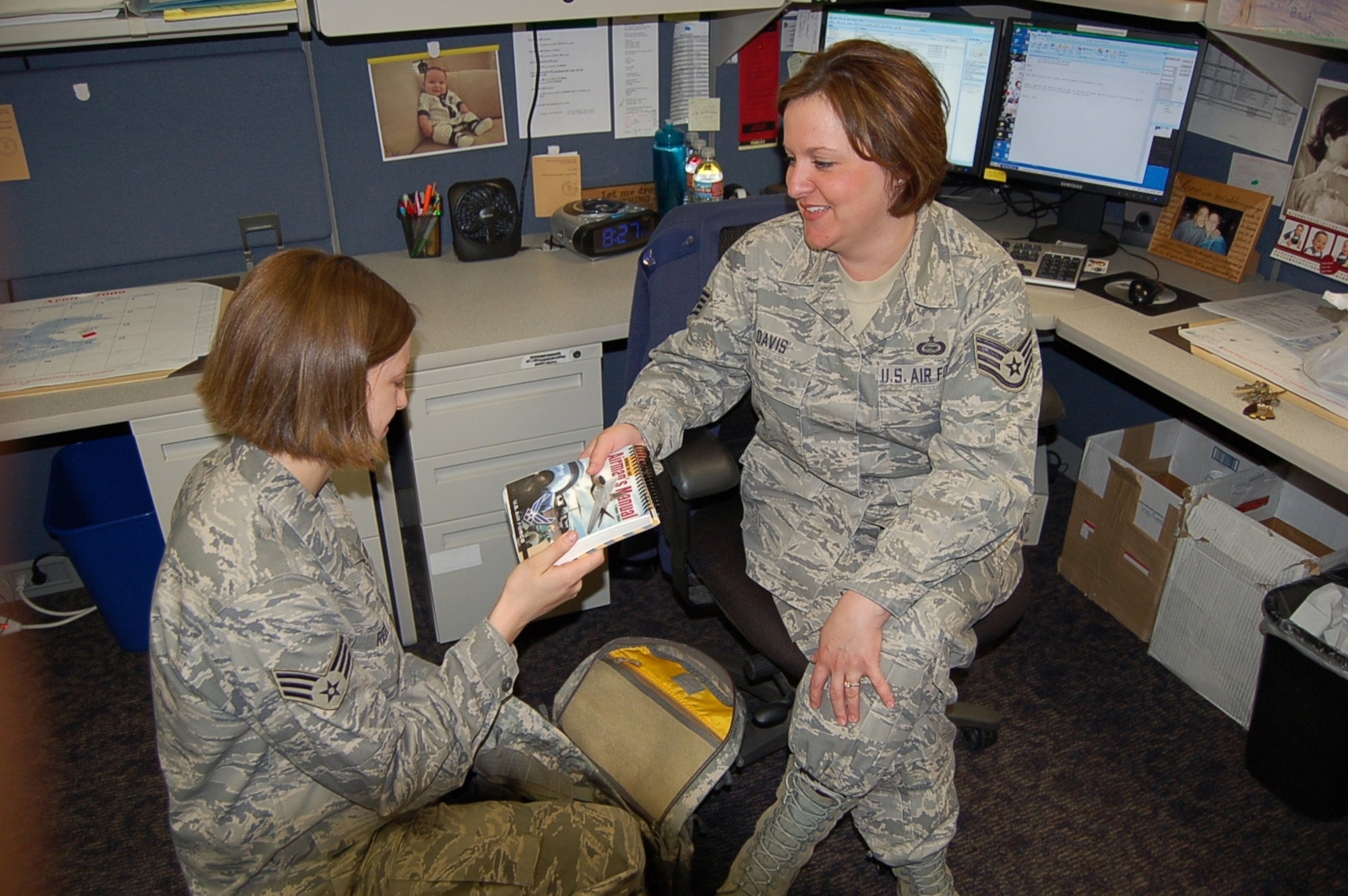BUCKLEY AIR FORCE BASE, Colo. -- Staff Sgt. Linda Davis(right) ensures an Airman is ready for deployment with an Airmans Manual.  Sergeant Davis, Unit Deployment Manager for the 566th Intelligence Squadron, is Team Buckley's Warrior of the Week for May 1-7.  She hails from Sacramento, Calif. (Courtesy photo) 
