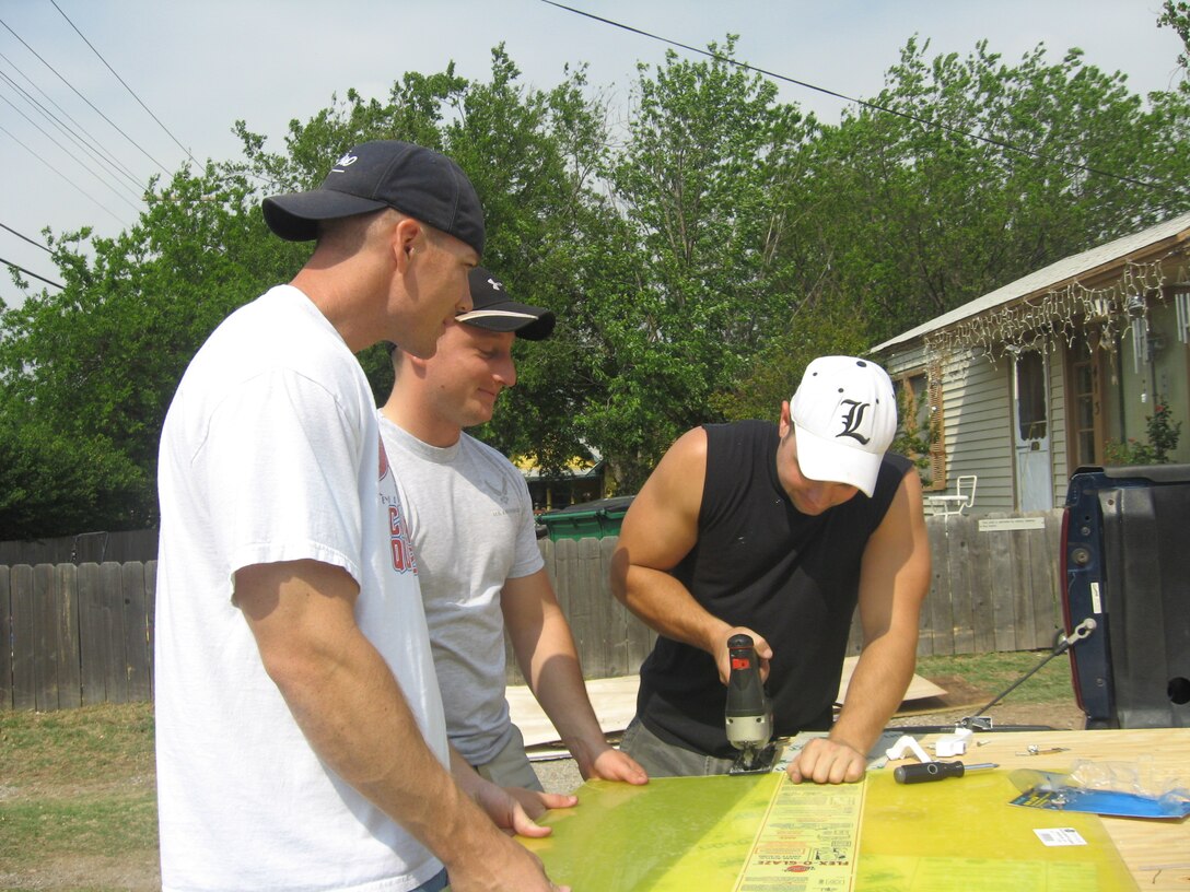 Staff Sgt. Justin Clark, Staff Sgt. Jason Bales and Tech. Sgt. Terry Doll are Team Sheppard members from the 360th TRS, are cutting plexi-glass as safety window replacements for a Burkburnett house renovation April 25 as part of Christmas in Action 2009.(U.S. Air Force photo/Debi Smith)