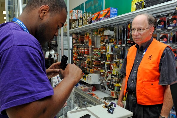 BARKSDALE AFB, La.-Tom Supak, AAFES Supervisor, shows Senior Airman Durell Marshall, 2d Logistics Readiness Squadron supply technician a pistol at the Gun Shop in the Barksdale AFB Base Exchange. The gun shop opened in November 2006 and has sold more than $100,000 in weapons, ammunition and accessories since that date. (USAF photo/TSgt Laura K. Smith) 
