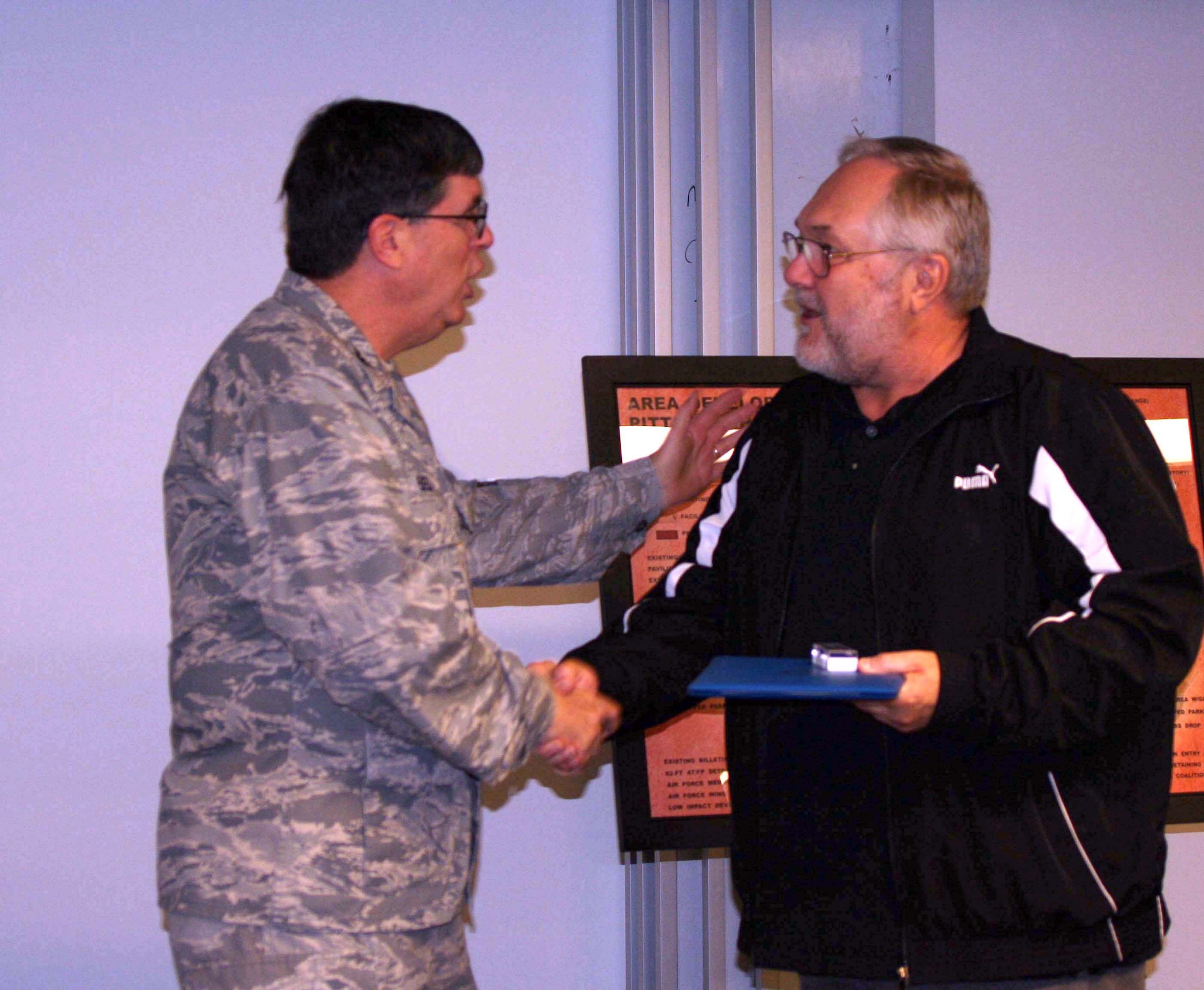 Mr. Henry Bullion, a Quality Assurance Evaluator with the 911th Mission Support Group, receives a service award for his more than 40 years of government service from Col. Gordon Elwell, 911th Airlift Wing commander, during the April Civilian Commander’s Call held here, April 21.(U.S Air Force photo by Staff. Sgt Roberto Modelo)