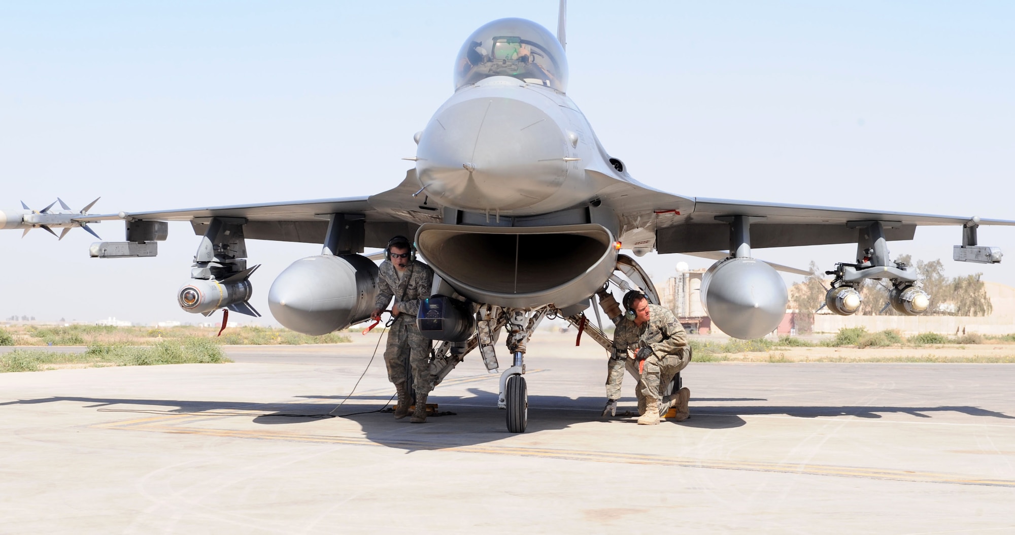 JOINT BASE BALAD, Iraq — Airman 1st Class Thomas Shepard, 332nd Expeditionary Aircraft Maintenance Squadron assistant dedicated crew chief, and Senior Airman David McAdams, 332nd EAMXS avionics technician journeyman, inspect an F-16 Fighting Falcon after it landed here recently. This F-16 became the first 40 block to surpass the 7,000-hour milestone. Black refers to the variant of the jet. Airman Shepard, a native of Rockhill, S.C., and Airman McAdams, a native of Huntsville Ala., are both deployed here from Hill Air Force Base, Utah. (U.S. Air Force photo/Senior Airman Tiffany Trojca)