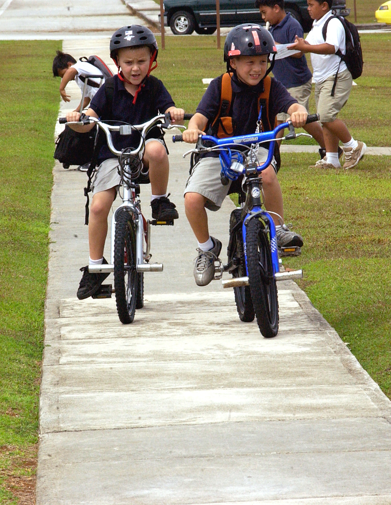 ANDERSEN AIR FORCE BASE, Guam -- Team Andersen school students make their way home April 28 while wearing proper protective equipment. The 36th Wing Safety Office and the 36th Security Forces Squadron implemented a joint program called "Get Caught Doing it Right" April 7. The program targets school age children using required safety gear correctly and provides incentives for kids found doing it right. (U.S. Air Force photo by Airman Carissa Wolff)