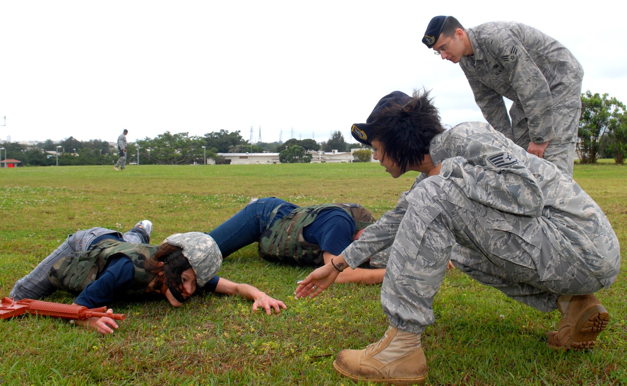 U.S. Air Force Staff Sgt. Avriel Campbell and Senior Airman Christopher Creel, both from the 18th Security Forces Squadron, instruct recruits in the Delayed Enlistment Program, how to properly low-crawl as part of the "Day at BMT" program April 25 at Kadena Air Base, Japan. The program was started to help prepare new recruits for Basic Military Training.
(U.S. Air Force photo/Staff Sgt. Angelique Perez)