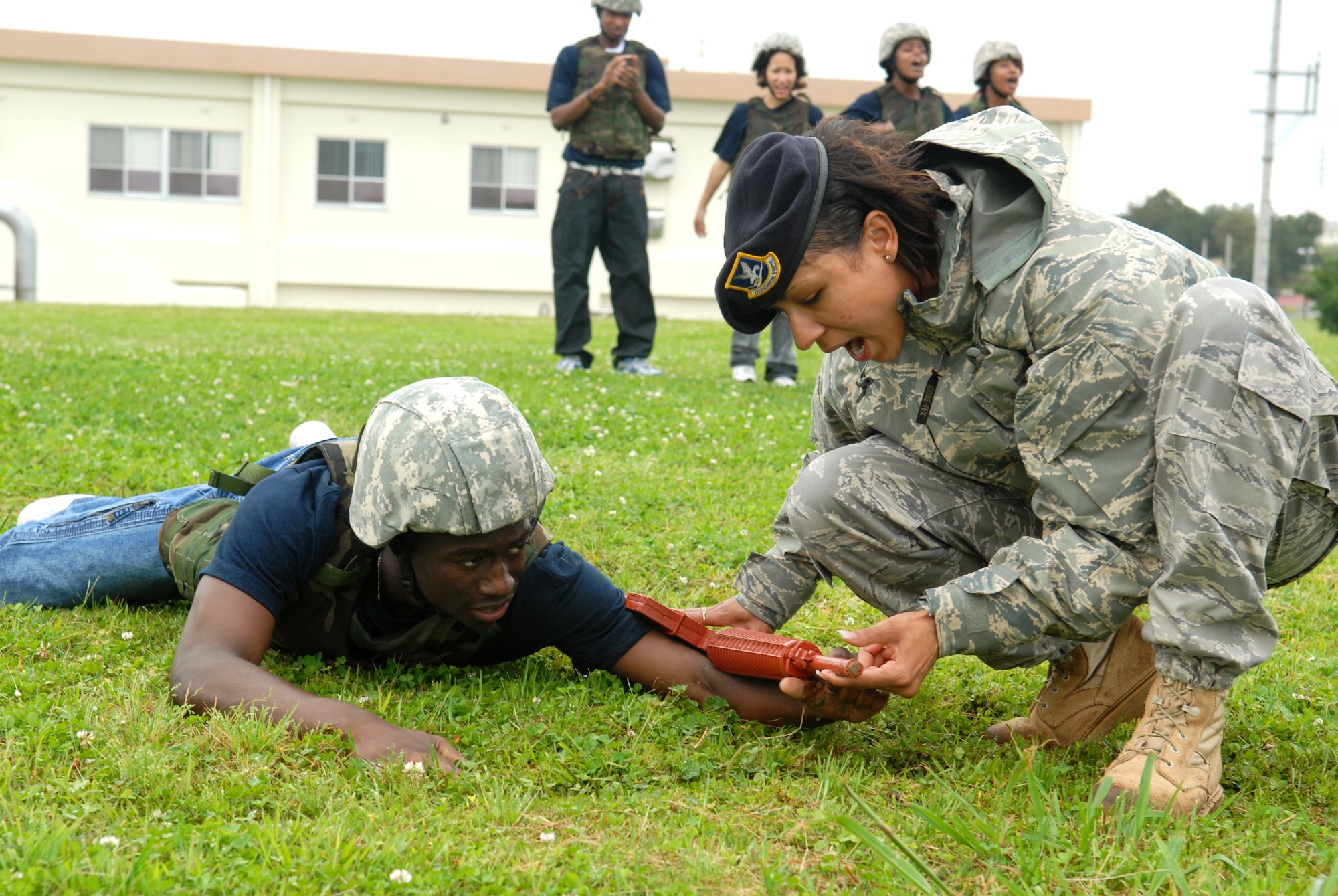 U.S. Air Force Staff Sgt. Avriel Campbell, from the 18th Security Forces Squadron, instructs Devin Roseboro, a recruit in the Delayed Enlistment Program, how to properly low-crawl as part of the "Day at BMT" program April 25 at Kadena Air Base, Japan. The program was started to help prepare new recruits for Basic Military Training.
(U.S. Air Force photo/Staff Sgt. Angelique Perez)