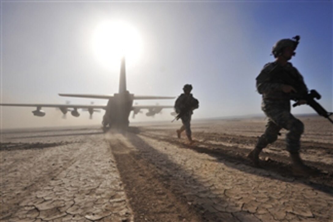 U.S. Army soldiers from 2nd Battalion, 18th Field Artillery Regiment run to set up a perimeter around a U.S. Air Force HC-130P Hercules during a training exercise in Djibouti on April 23, 2009.  The exercise consisted of transporting pararescuemen to their water jump, aerial refueling of a CH-53E Super Stallion helicopter, an assault landing on an unimproved runway and transfer/loading a simulated survivor from the CH-53E.  