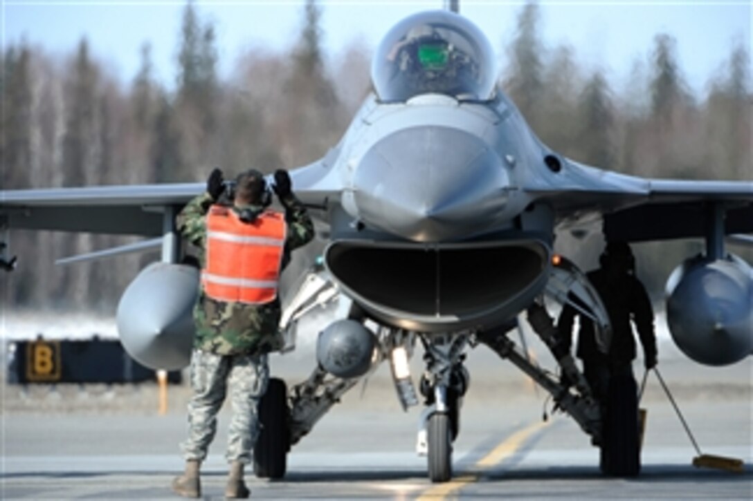U.S. Air Force Staff Sgt. Jason Lewey from the 8th Aircraft Maintenance Squadron marshals an F-16 Fighting Falcon from the 35th Fighter Squadron at Kunsan Air Base, South Korea, after returning from a training mission during RED FLAG-Alaska 09-2 at Eielson Air Force Base, Alaska, on April 20, 2009.  RED FLAG-Alaska provides training for deployed maintenance and support personnel in sustainment of a large-force deployed air operation.  