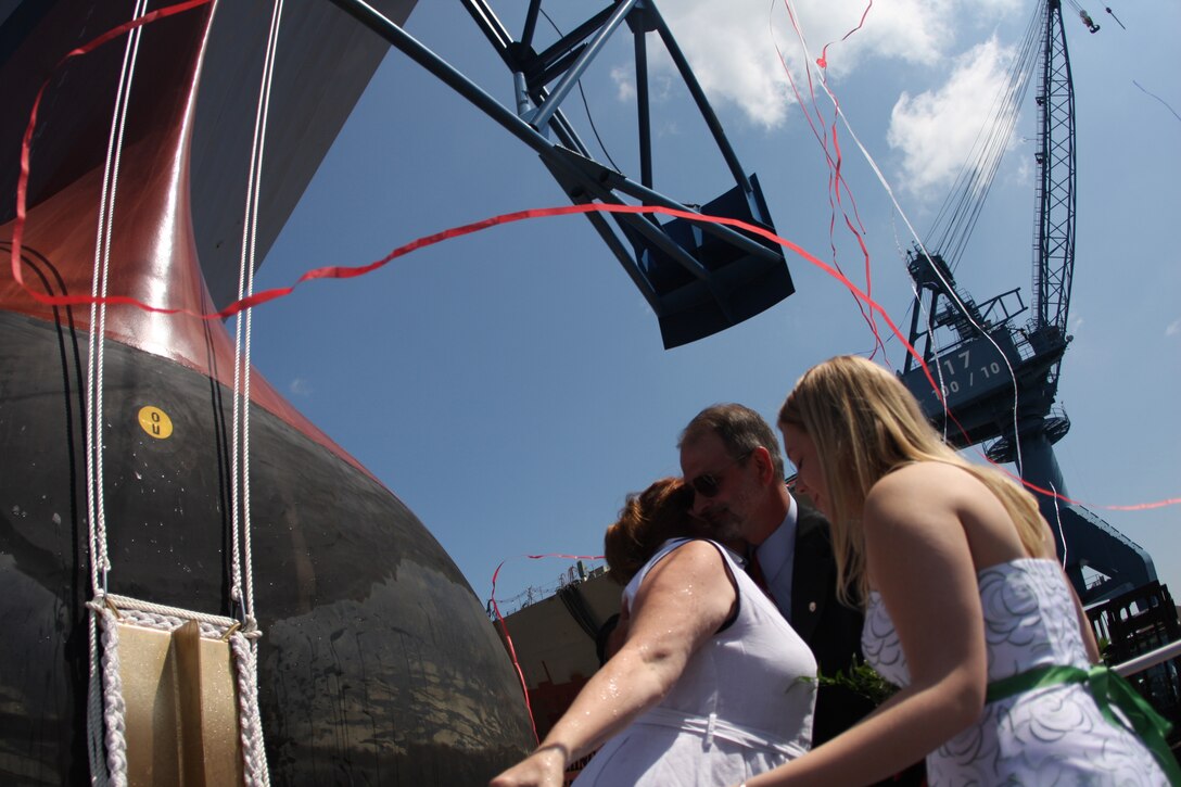 Deb, Dan and Katie Dunham, Medal of Honor recipient Cpl. Jason Dunham's family, celebrate the christening of the Navy's newest destroyer which bears the name of the name of their beloved son and brother during the christening ceremony held Aug. 1 at Bath Iron Works in Bath, Maine.