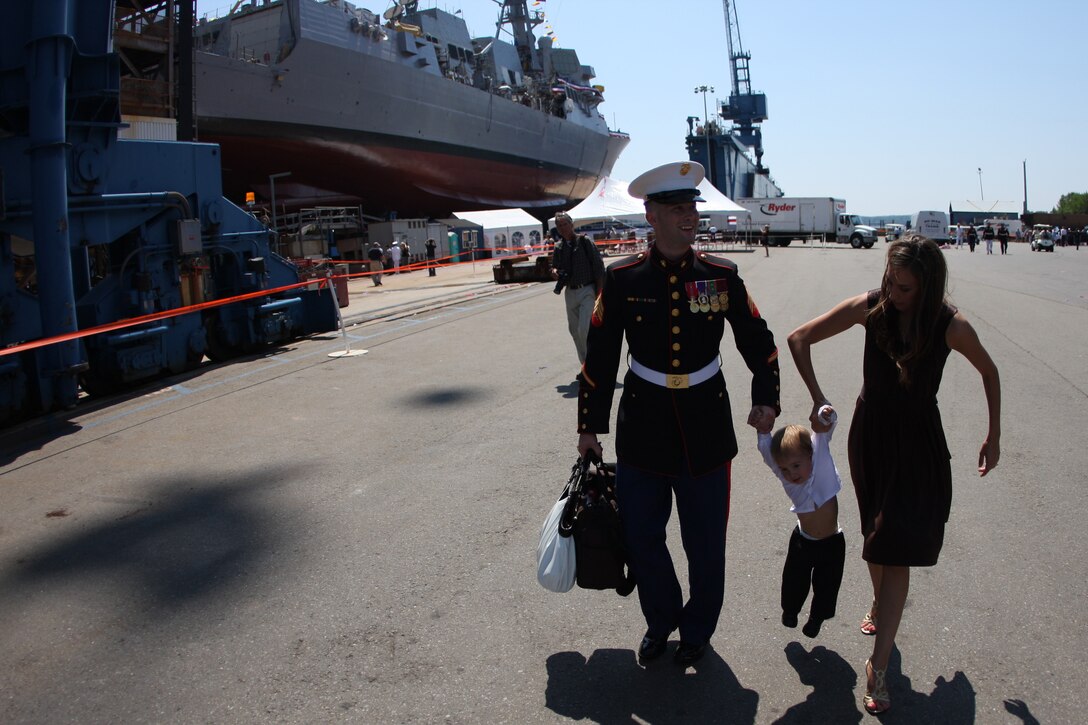 Sgt. Mark Dean, one of Medal of Honor recipient Cpl. Jason Dunham's close friends, and his wife Becky lift their 18 month-old son, Aiden, after the christening of the Navy destroyer bearing his friends name Aug. 1 at Bath Iron Works in Bath, Maine.