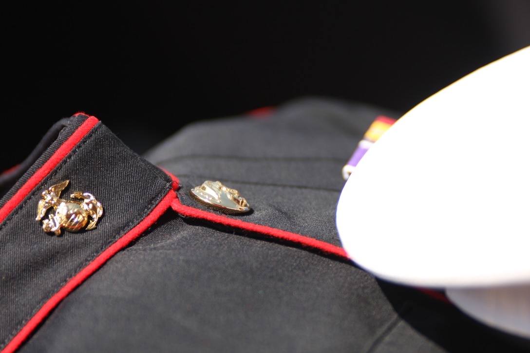 The dress blue uniform of the first Marine to be awarded the Medal of Honor since Vietnam, Cpl. Jason Dunham, are proudly held before the christening of the Navy destroyer USS Jason Dunham Saturday at Bath Iron Works in Bath, Maine.