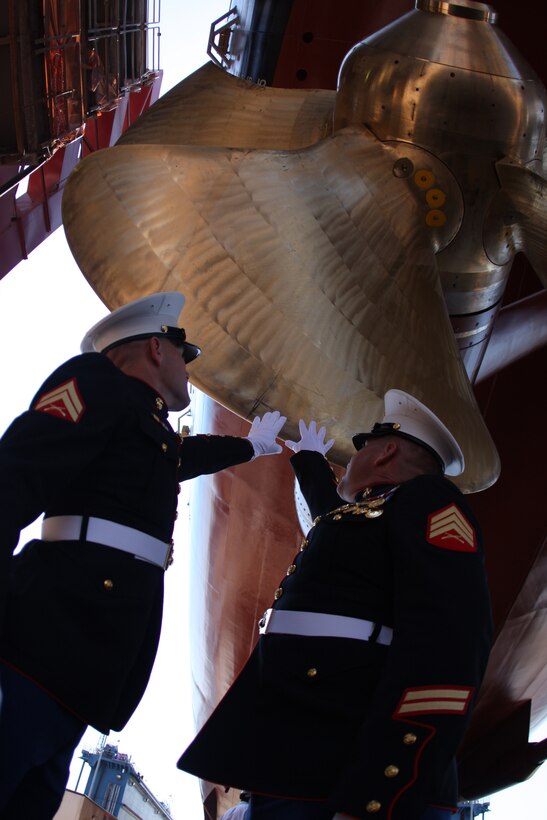 Cpl. Kelly Miller and Sgt. Bill Hampton, the two Marines whose lives were saved by Cpl. Jason Dunham's actions which earned him the Medal of Honor, touch the propeller, or "screw," of the ship named after their fallen hero and friend after it's christening Saturday at Bath Iron Works in Bath, Maine.