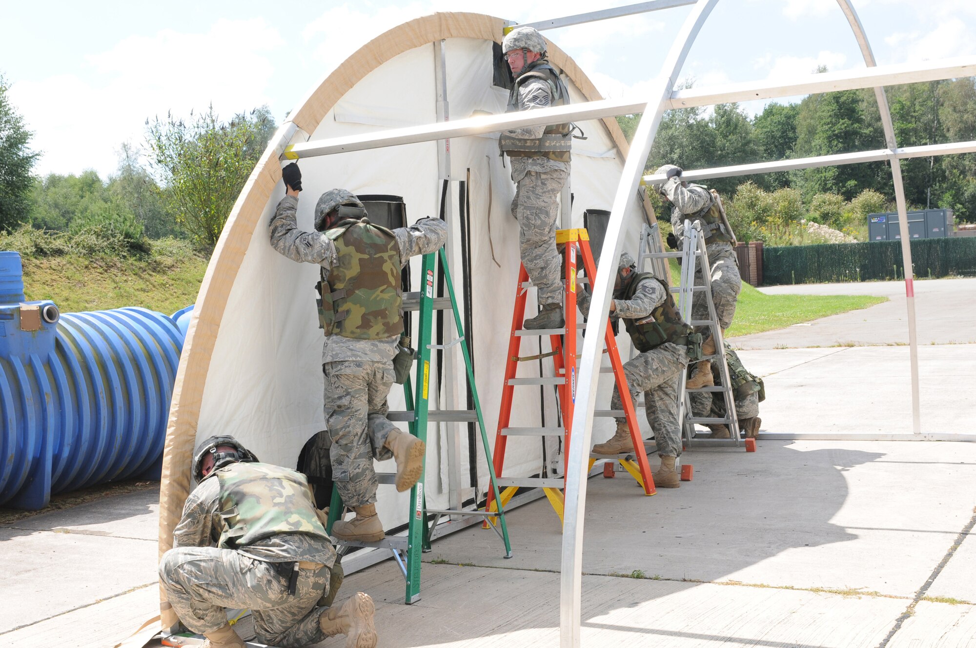 Members from both Ramstein Air Base, Germany and Aviano Air Base, Italy, assemble a small shelter system during a seven day contingency skills training course August 1, 2009.  Members throughout United States Air Forces in Europe participate in the mandated seven day training hels on Ramstein Air Base, Germany, for civil engineers, services, logistics, medical and personnelists. (U.S. Air Force photo by: Tech. Sgt. Sean Mateo White)