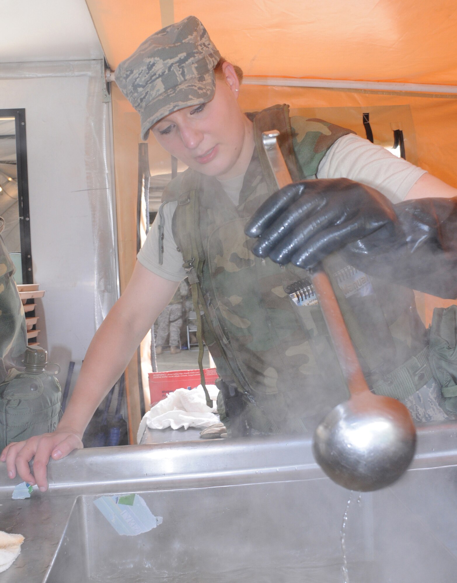 Airman First Class Yelizaveta Semmom, 86th Services Squadron, Ramstein Air Base, Germany, cleans the cooking utensils after serving a hot lunch while participating in a week long contingency exercise Silver Flag.  Members throughout United States Air Forces in Europe participated in the mandated seven day training for civil engineers, services, logistics, medical and personnelists. (U.S. Air Force photo by: Tech. Sgt. Sean Mateo White)