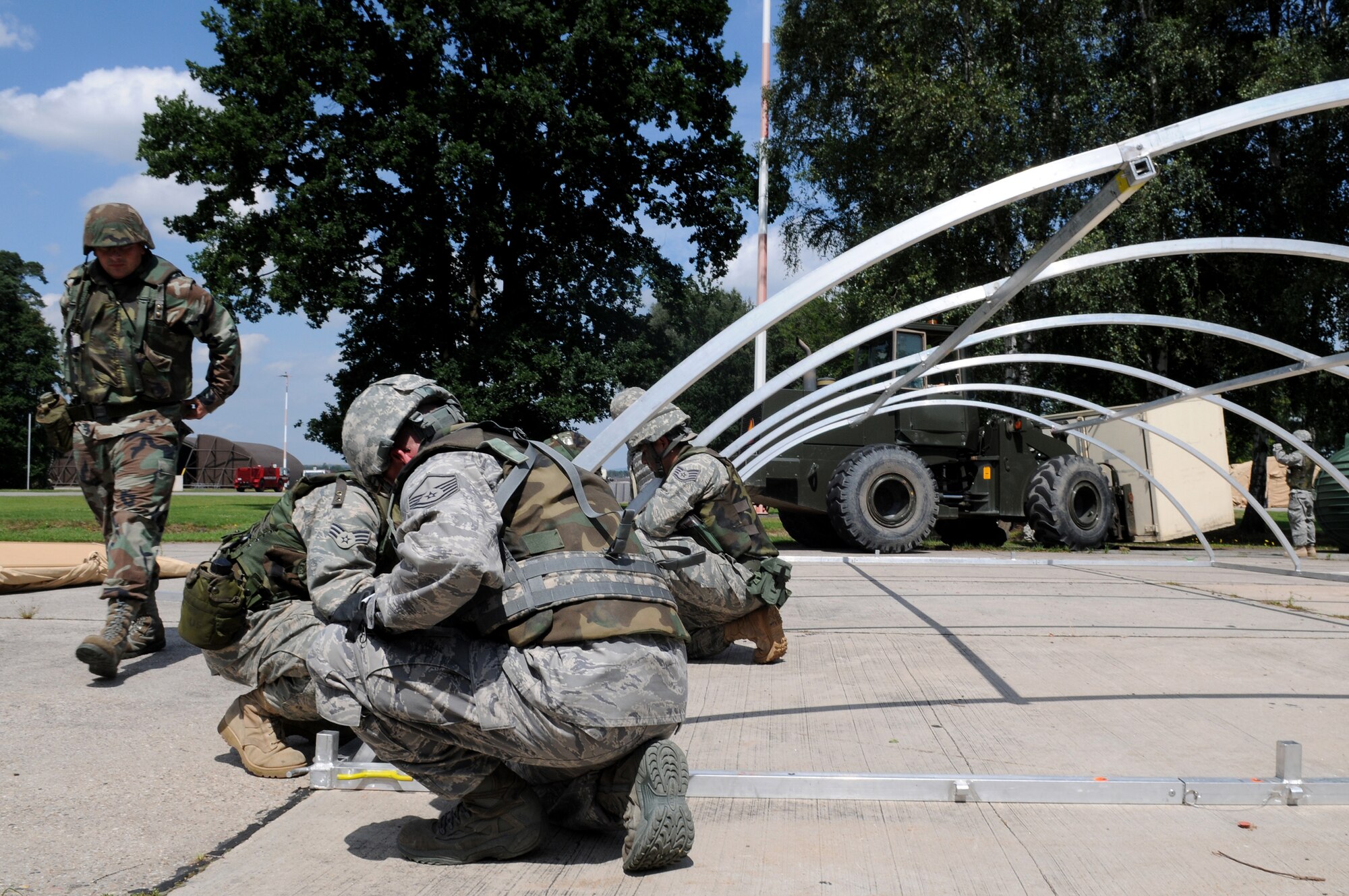 U.S. Air Force Airmen of different bases, wings, and squadrons work together to build a small shelter system tent during the Silver Flag exercise on Ramstein Air Base, Germany, Aug. 1, 2009. There are about nine to ten Silver Flag exercises held throughout the year at the Construction Training Squadron, and the average class size is 100 to 200 people. (U.S. Air Force photo by Airman 1st Class Grovert Fuentes-Contreras)(Released)