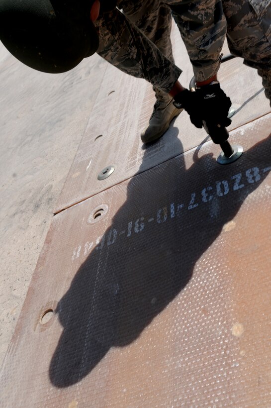 U.S. Air Force Senior Airman Dino Parrella, 65th Civil Engineer Squadron, ensures bolts are safe after completing the Airfield Damage Repair exercise during the Silver Flag exercise on Ramstein Air Base, Germany, Aug. 1, 2009. The Silver Flag exercise gives participants the basic contingency skills to set up a bed down operation anywhere in the world. (U.S. Air Force photo by Airman 1st Class Grovert Fuentes-Contreras)(Released)