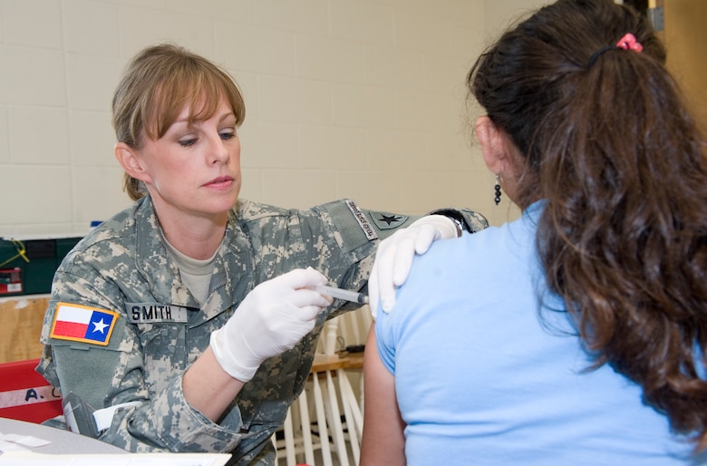 Texas State Guard Army Capt. Jodie Smith inoculates a young resident to fulfill her school required immunizations she would otherwise not receive at Operation Lone Star held at Dr. Javier Saenz Middle School, Penitas, Texas, July 29, 2009. (U.S. Air Force photo by Tech Sgt. Charles Hatton)