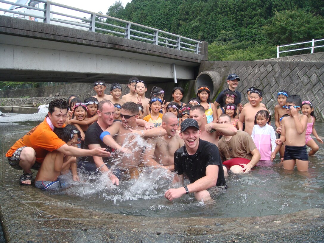 Station community members and Futashika community members take a moment Aug. 1 to gather in the Futashika communities children’s pool after spending the day cleaning  out the large rocks, gravel and sediment washed into the pools by recent rain storms. Community members gave up most of their Saturday and spent more than seven hours cleaning out the Futashika communities pools.