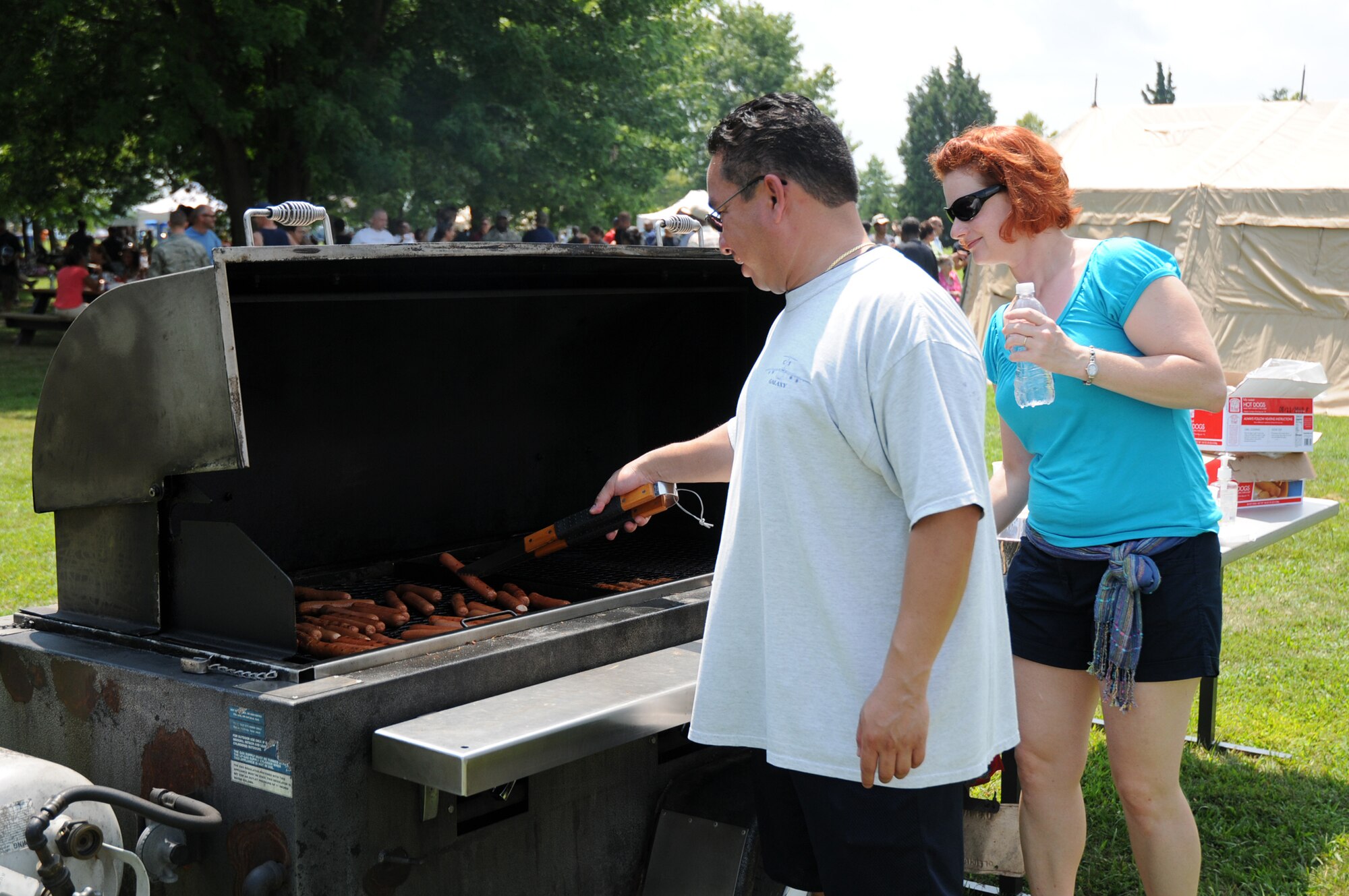 Senior Airman Juan Tristan, 512th Aircraft Maintenance Squadron, and Tech. Sgt. Karla Rust, 712th AMXS, prepare food for the 512th Airlift Wing picnic Aug. 1 at the Eagle's Nest picnic area.  More than 1,100 reservists and their families attended the biannual picnic. (U.S. Air Force photo/Capt. Marnee A.C. Losurdo)