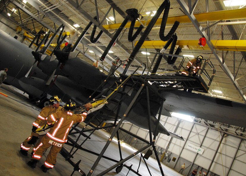 Firefighters hold the rope to lower the stretcher from the wing of a C-130, while others collect the victim at the bottom as part of a simulated confined space exercise Aug. 1 at Duke Field.  Maintainers and firefighters participated in the simulated accident and response exercise.  Evaluators watched to ensure the proper steps are known and taken in the case of an emergency.  (U.S. Air Force photo/Staff Sgt. Samuel King Jr.)