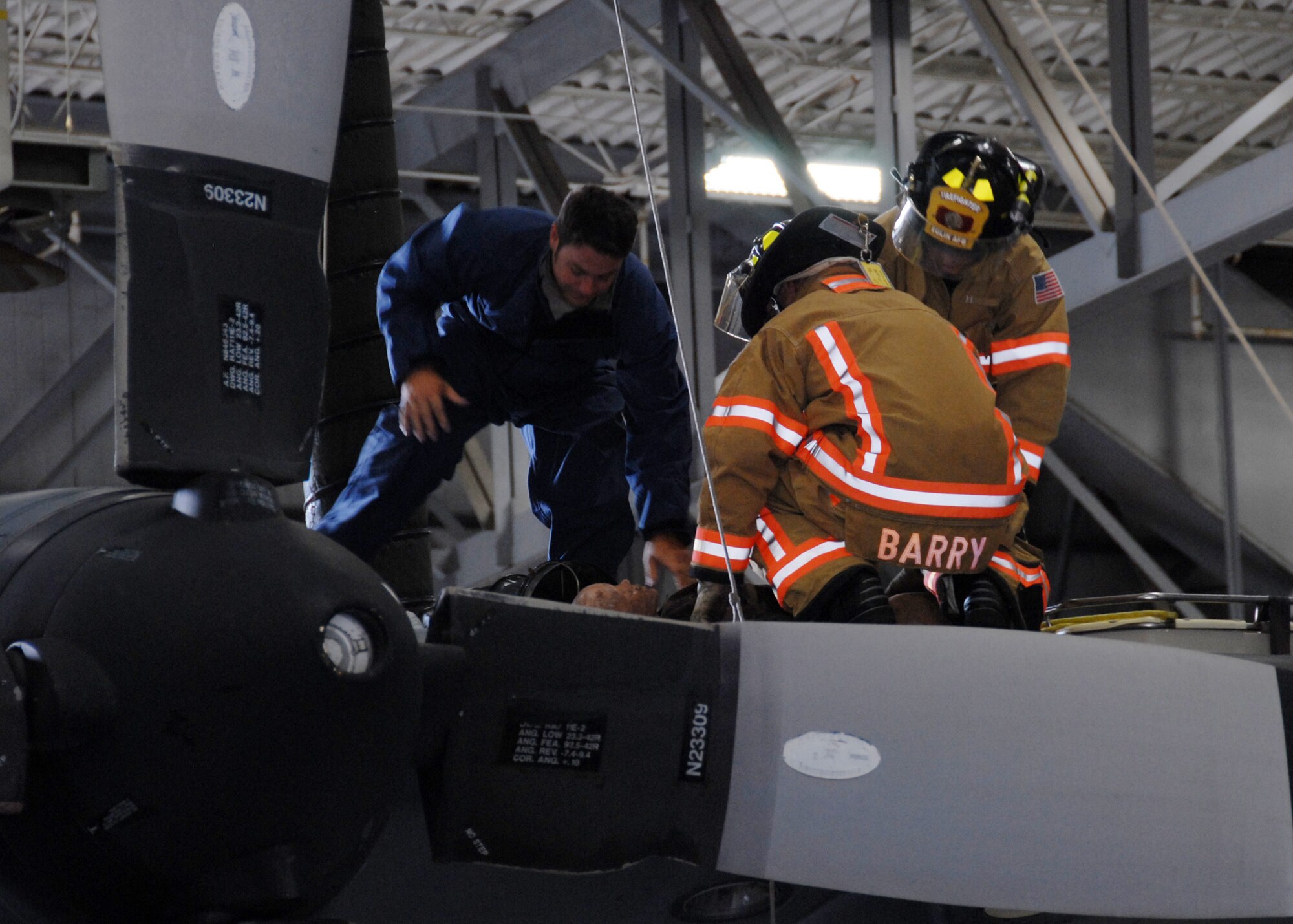 Tech. Sgt. David Dean, 919th Maintenance Squadron, assists firefighters with moving the victim of a simulated confined space exercise Aug. 1 at Duke Field.  Maintainers and firefighters participated in the simulated accident and response exercise.  Evaluators watched to ensure the proper steps are known and taken in the case of an emergency.  (U.S. Air Force photo/Staff Sgt. Samuel King Jr.)