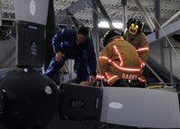 Tech. Sgt. David Dean, 919th Maintenance Squadron, assists firefighters with moving the victim of a simulated confined space exercise Aug. 1 at Duke Field.  Maintainers and firefighters participated in the simulated accident and response exercise.  Evaluators watched to ensure the proper steps are known and taken in the case of an emergency.  (U.S. Air Force photo/Staff Sgt. Samuel King Jr.)